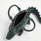 Green alligator-shaped handbag on a white background
