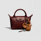 Brown handbag with a matching keychain on a light gray background